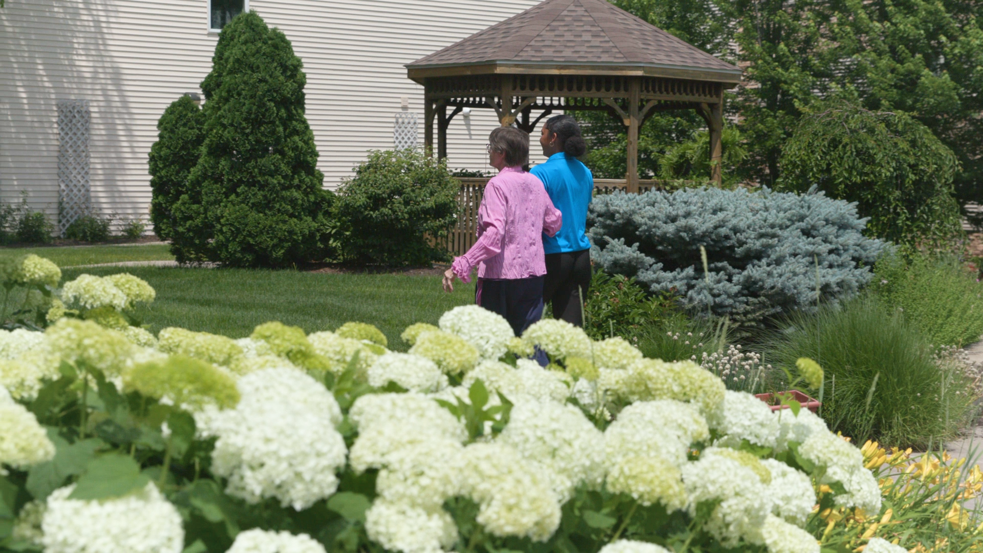 Women walking in garden with views of cedar rapids